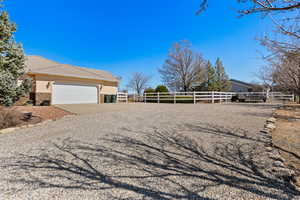 Exterior space featuring fence, an attached garage, stucco siding, concrete driveway, and a tile roof