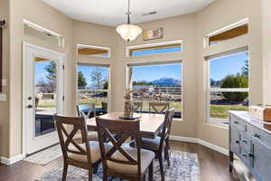 Dining area with visible vents, baseboards, and dark wood-style flooring