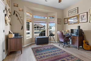 Office space featuring light wood-style flooring, baseboards, and ceiling fan