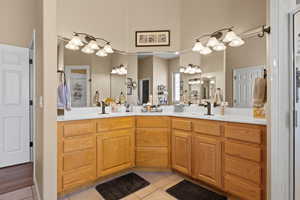 Bathroom with tile patterned floors, double vanity, a towering ceiling, and a sink