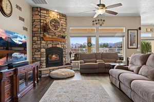 Living area featuring visible vents, wood finished floors, a textured ceiling, and ceiling fan