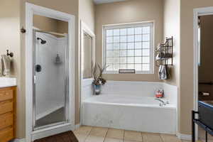 Bathroom featuring tile patterned flooring, a shower stall, vanity, and a bath
