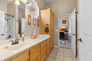 Full bathroom with tile patterned flooring, toilet, vanity, and a shower