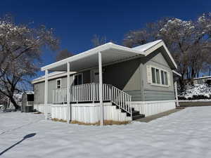 Manufactured / mobile home featuring an attached carport, a porch, and central AC