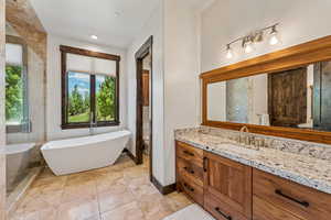 Full bath featuring a freestanding bath, vanity, and recessed lighting
