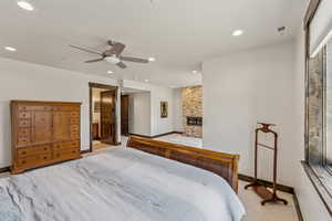 Bedroom with recessed lighting, light carpet, a fireplace, and a ceiling fan