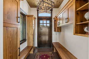 Mudroom with a chandelier and dark wood-style flooring