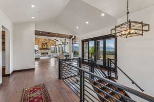 Corridor with an upstairs landing, a chandelier, recessed lighting, hardwood / wood-style floors, and high vaulted ceiling