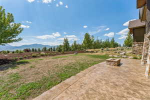 View of yard featuring a fire pit, a patio area, and a mountain view