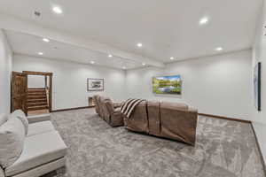 Carpeted living room featuring recessed lighting and stairs