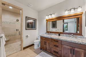 Full bathroom with double vanity, a shower stall, and wood finished floors