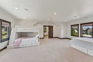 Bedroom with a barn door, light carpet, and recessed lighting