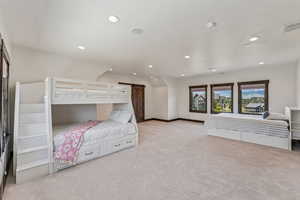 Bedroom featuring a barn door, light colored carpet, and recessed lighting