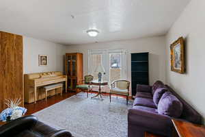 Living room with french doors, a textured ceiling, and dark wood-style flooring