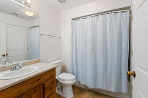 Bathroom with tile patterned flooring, toilet, vanity, and visible vents