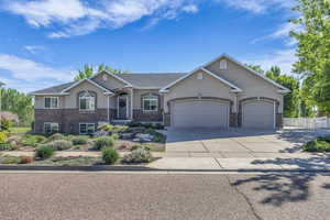 Ranch-style home featuring stucco siding, an attached garage, concrete driveway, and fence