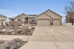 Ranch-style home with fence, stucco siding, concrete driveway, a garage, and brick siding