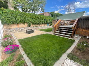 View of yard featuring a fire pit, a deck, a patio area, and stairs