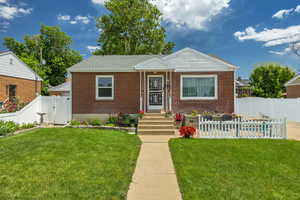 Bungalow-style home featuring brick siding, a fenced backyard, and a gate
