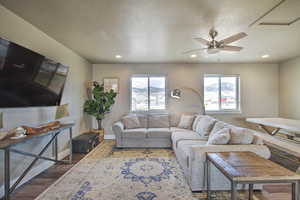 Living room with baseboards, recessed lighting, wood finished floors, a textured ceiling, and a ceiling fan