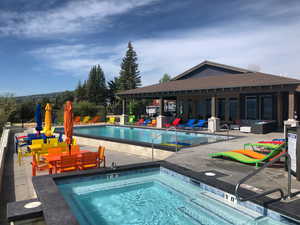 Community pool featuring a hot tub, outdoor lounge area, a patio, and fence