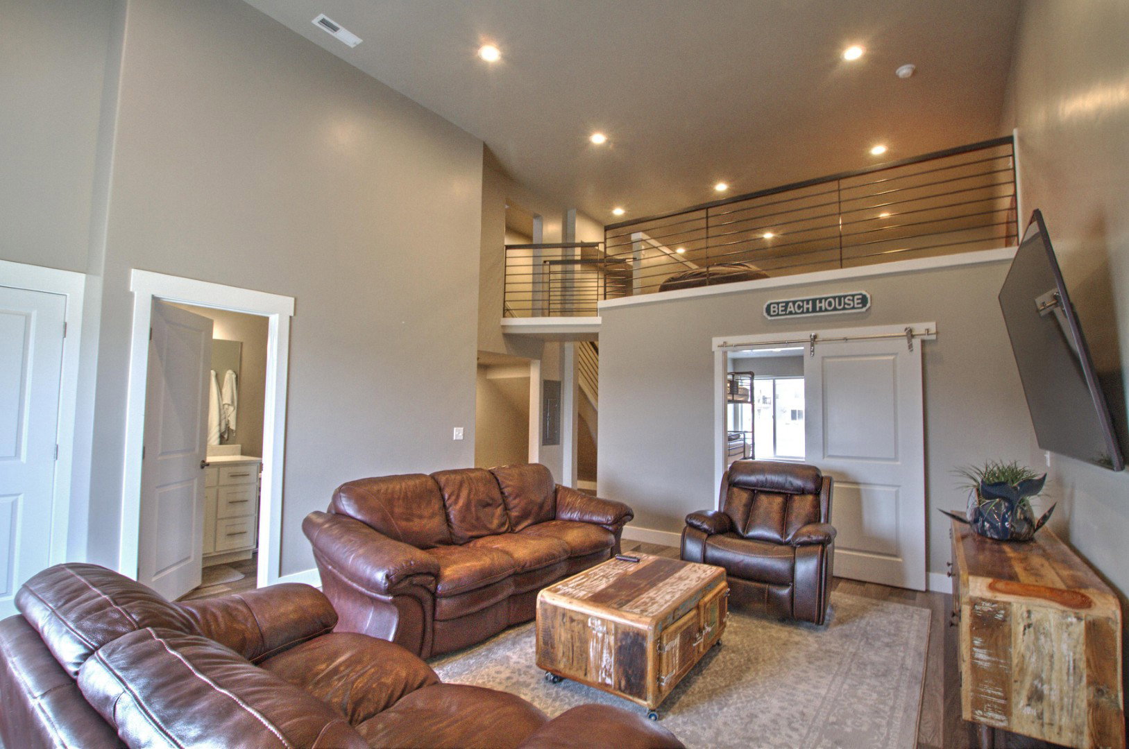 Living area featuring recessed lighting, visible vents, a towering ceiling, and baseboards