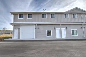 Multi unit property featuring a garage and board and batten siding
