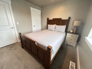 Bedroom featuring visible vents and light carpet