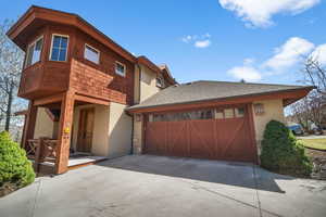 View of front of property with driveway, stucco siding, and a garage