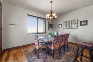 Dining space with light wood-style floors, an inviting chandelier, and baseboards