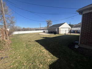 View of yard featuring an outbuilding, a detached garage, and a fenced backyard