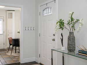 Foyer entrance featuring a wealth of natural light and baseboards