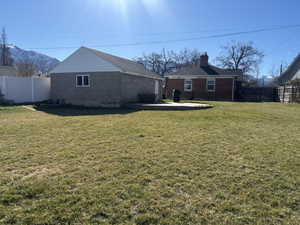 View of yard with fence, a mountain view, and a patio area