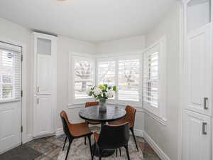 Dining space featuring baseboards and stone tile floors