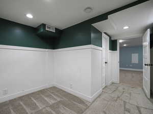 Carpeted spare room with visible vents and recessed lighting