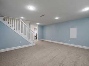 Finished below grade area with baseboards, carpet floors, and stairs
