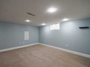 Below grade area featuring visible vents, baseboards, and carpet flooring