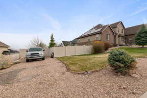 View of side of property featuring fence and a yard