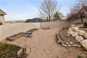 View of yard featuring a fenced backyard and a garden