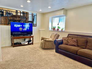 Carpeted living area featuring baseboards, recessed lighting, visible vents, and a textured ceiling