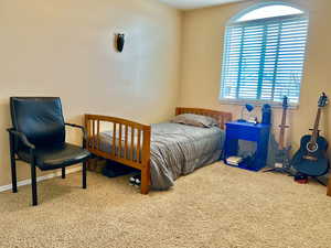 Bedroom featuring carpet and baseboards