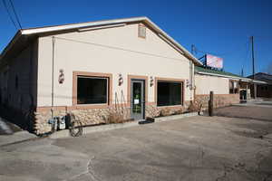 View of front facade featuring stone siding and stucco siding