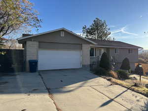 Single story home featuring brick siding, driveway, a garage, and fence