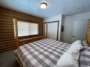 Carpeted bedroom with a closet and a textured ceiling