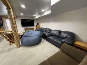 Living room with carpet, recessed lighting, and a textured ceiling