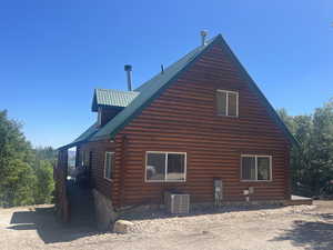View of home's exterior featuring log siding, central air condition unit, and metal roof