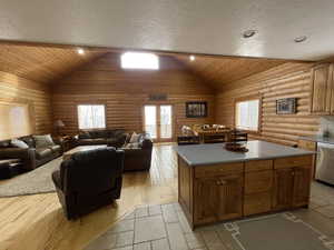 Kitchen with stainless steel dishwasher, french doors, brown cabinets, and a center island
