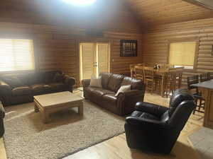 Living room featuring rustic walls, lofted ceiling, and wood finished floors