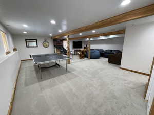 Rec room featuring carpet, baseboards, recessed lighting, a textured ceiling, and beamed ceiling