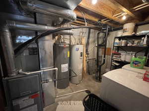 Utility room with water heater and washer and dryer